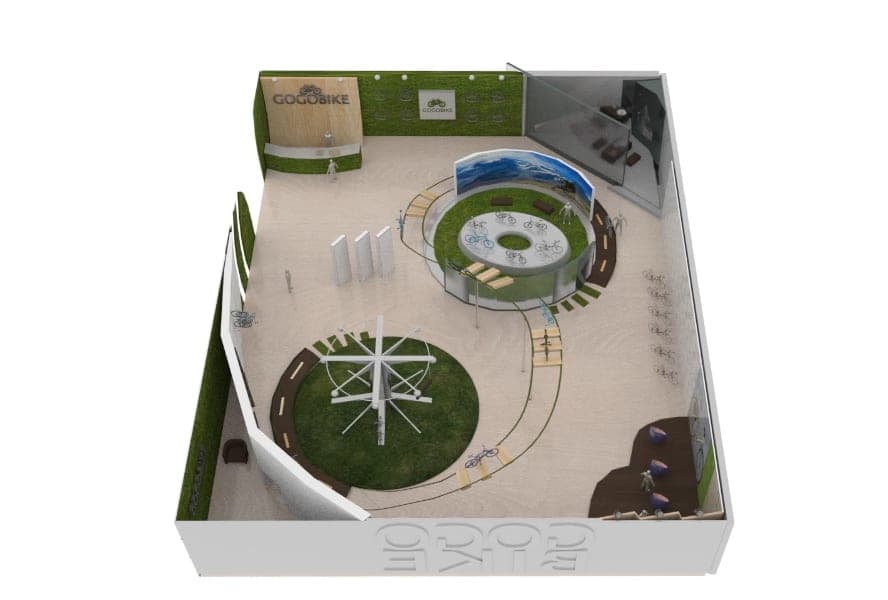 Bird's-eye 3D render of the GOGOBIKE booth: wood reception wall, circular grass-roofed bike display, turbine sculpture, and a winding bike-path floor.