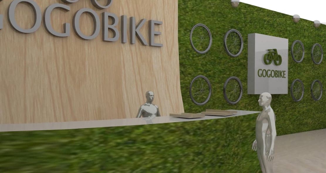Close 3D render of the GOGOBIKE reception: wooden wall with 3D logo letters, moss wall mounted with bicycle wheels, brand sign, and mannequin staff.