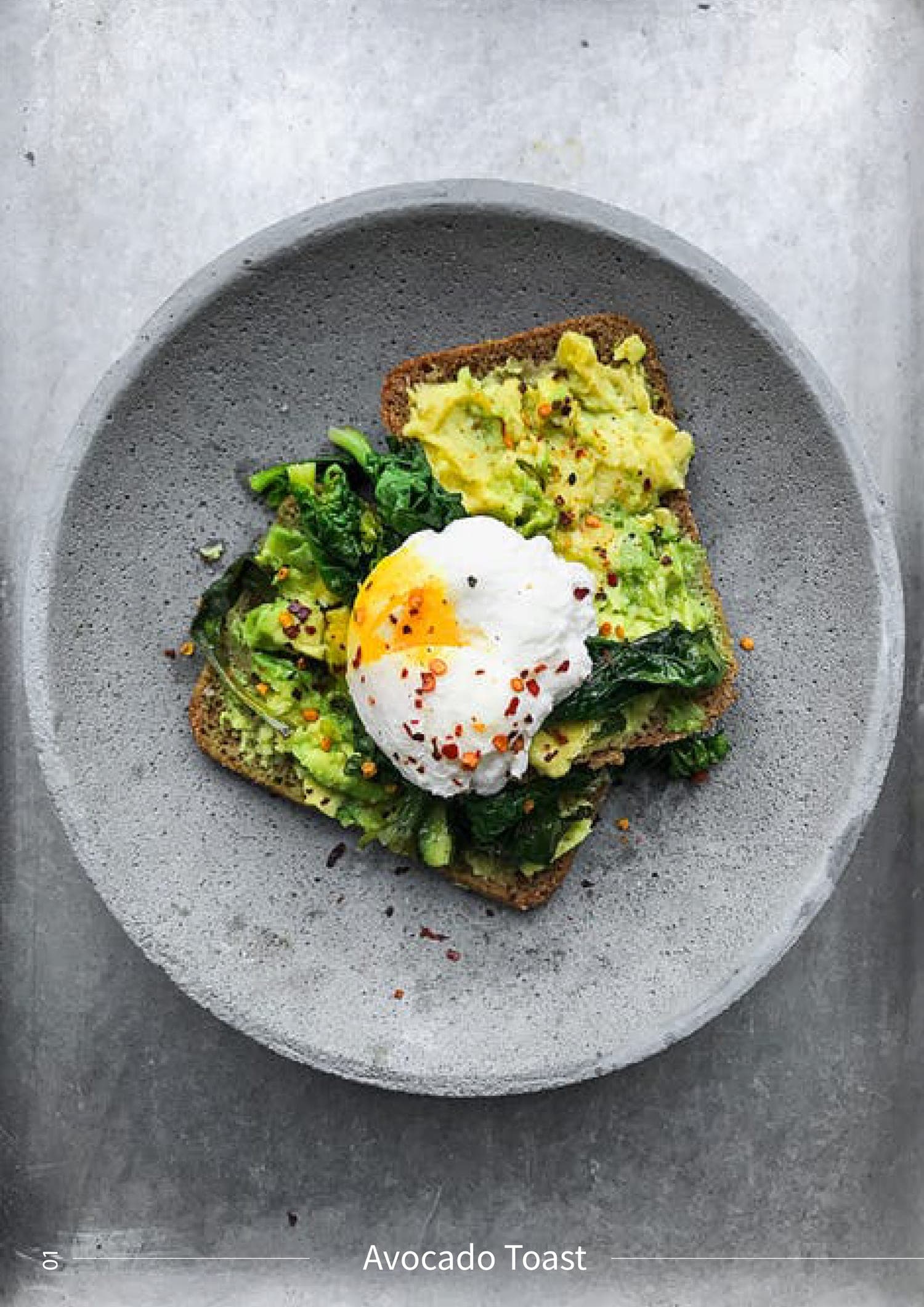 Full-bleed overhead photo of avocado toast with a poached egg and chili flakes on a gray stone plate, captioned Avocado Toast at the bottom.
