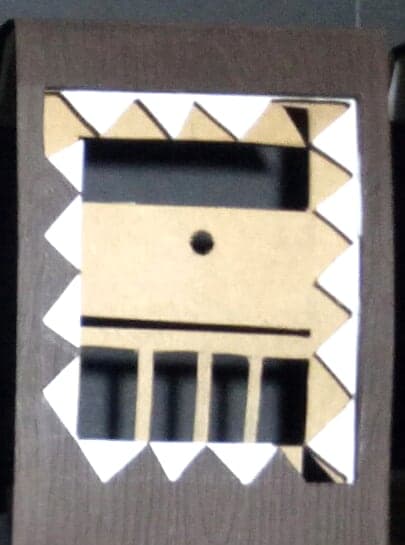 Leo chocolate box: geometric paper-cut sign emblem on dark wood-textured paper