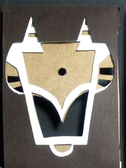 Taurus chocolate box: geometric paper-cut sign emblem on dark wood-textured paper